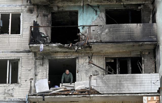 A local resident of a damaged residential building looks on as he clears debris following Russian strike in Kyiv on May 24, 2025, amid Russian invasion in Ukraine. A massive Russian drone and missile attack on Kyiv on May 24, 2025 wounded at least 15 people, even as Russia and Ukraine continued the biggest prisoner swap since the start of Moscow's invasion. Ukraine's air force said Russia launched 14 ballistic missiles and 250 attack drones overnight, adding that it downed six missiles and 245 drones. (Photo by Sergei SUPINSKY / AFP)