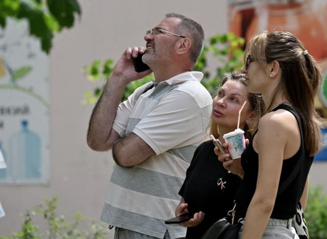 Local residents and neighbors of multistorey residential building look at the damage to the building following a Russian drone strike in Kyiv on May 24, 2025, amid Russian invasion in Ukraine. A massive Russian drone and missile attack on Kyiv on May 24, 2025 wounded at least 15 people, even as Russia and Ukraine continued the biggest prisoner swap since the start of Moscow's invasion. Ukraine's air force said Russia launched 14 ballistic missiles and 250 attack drones overnight, adding that it downed six missiles and 245 drones. (Photo by Sergei SUPINSKY / AFP)