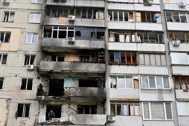 Local residents of a multistory residential building clear debris in their flats damaged following Russian drone strike in Kyiv on May 24, 2025, amid Russian invasion in Ukraine. At least eight people were wounded in a drone and missile attack on Kyiv on May 24, 2025, city authorities said, just as Russia and Ukraine were in the middle of a major prisoner swap. The head of Kyiv's civil and military administration, Tymur Tkachenko, reported fires and fallen debris in several parts of the Ukrainian capital, after AFP journalists heard explosions overnight. (Photo by Sergei SUPINSKY / AFP)