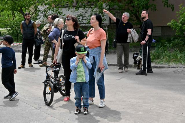 Local residents and neighbors of multistorey residential building look at the damage to the building following a Russian drone strike in Kyiv on May 24, 2025, amid Russian invasion in Ukraine. A massive Russian drone and missile attack on Kyiv on May 24, 2025 wounded at least 15 people, even as Russia and Ukraine continued the biggest prisoner swap since the start of Moscow's invasion. Ukraine's air force said Russia launched 14 ballistic missiles and 250 attack drones overnight, adding that it downed six missiles and 245 drones. (Photo by Sergei SUPINSKY / AFP)