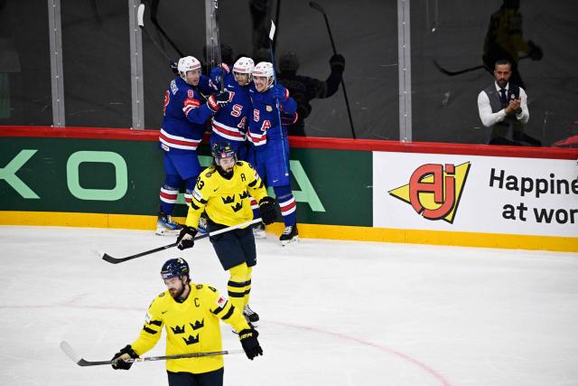 Sweden's Rasmus Andersson and Sweden's Mika Zibanejad are seen in the foreground as US forward #23 Michael Eyssimont (background, R) celebrates with teammates after scoring the 0-3 goal during the IIHF Men's Ice Hockey World Championship semi-final match between Sweden and USA in Stockholm, on May 24, 2025. (Photo by Pontus LUNDAHL / TT NEWS AGENCY / AFP) / Sweden OUT