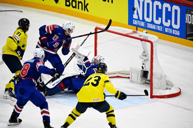 Sweden's players (yellow) attack US goalkeeper #01 Jeremy Swayman (C) during the IIHF Men's Ice Hockey World Championship semi-final match between Sweden and USA in Stockholm, on May 24, 2025. (Photo by Pontus LUNDAHL / TT NEWS AGENCY / AFP) / Sweden OUT