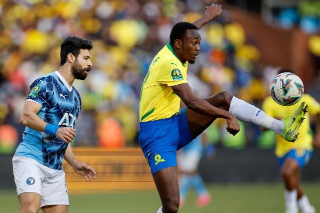 Sundowns' Namibian forward #38 Peter Shalulile (R) controls the ball away from Pyramids' Egyptian defender #4 Ahmed Samy (L) during the first leg of the CAF Champions League final football match between Mamelodi Sundowns and Pyramids Football Club at Loftus Versfeld stadium in Pretoria on May 24, 2025. (Photo by Phill Magakoe / AFP)