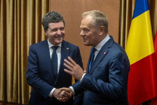 Poland's Prime Minister Donald Tusk (R) shakes hands with Romania's President-elect Nicusor Dan (L) during their meeting in Warsaw, Poland, on May 25, 2025. (Photo by Wojtek RADWANSKI / AFP)
