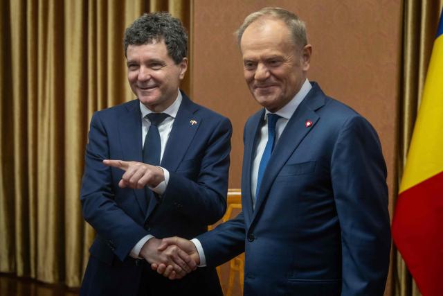 Poland's Prime Minister Donald Tusk (R) shakes hands with Romania's President-elect Nicusor Dan (L) during their meeting in Warsaw, Poland, on May 25, 2025. (Photo by Wojtek RADWANSKI / AFP)