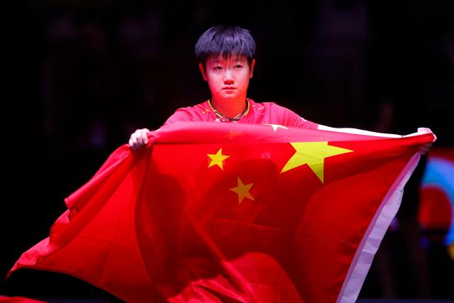 China's Sun Yingsha carries her country's flag after winning the women's single final match of the ITTF World Table Tennis Championships finals in Doha on May 25, 2025. (Photo by Karim JAAFAR / AFP)