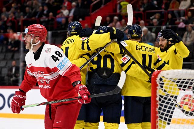 Denmark's defender #48 Nicholas Jensen (L) looks on as Sweden's forward #90 Marcus Johansson (C) celebrates with teammates after scoring the 5-2 goal during the IIHF Men's Ice Hockey World Championship third place playoff match between Sweden and Denmark in Stockholm, on May 25, 2025. (Photo by Jonathan NACKSTRAND / AFP)