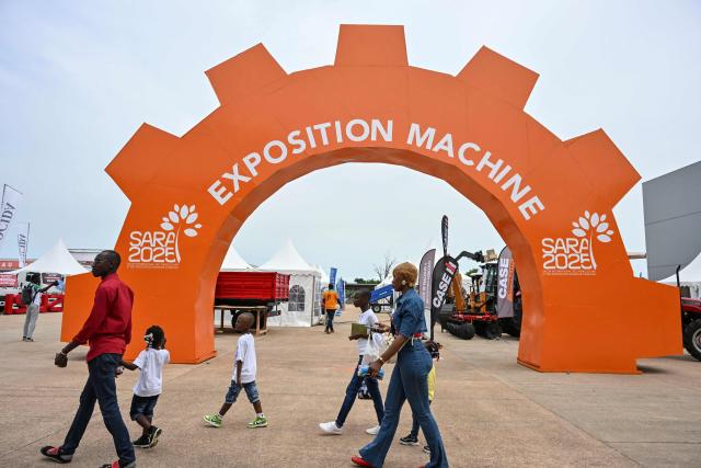 Visitors walks past agriculture machine pavilion during the 7th International Exhibition of Agriculture and Animals Resources (SARA-2025)at the Parcs des expositions in Abidjan on May 25, 2025 (Photo by Issouf SANOGO / AFP)