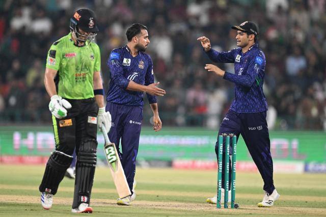 Quetta Gladiators' Faheem Ashraf (C) celebrates with teammate Hasan Nawaz (R) after taking the wicket of Lahore Qalandars' Mohammad Naeem (L) during the Pakistan Super League (PSL) Twenty20 final cricket match between Lahore Qalandars and Quetta Gladiators at the Qaddafi Cricket Stadium in Lahore on May 25, 2025. (Photo by Aamir QURESHI / AFP)