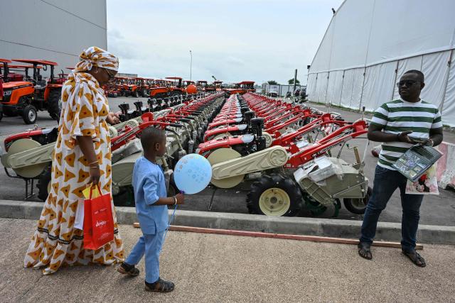 Visitors walks past agricutural tractors during the 7th International Exhibition of Agriculture and Animals Resources (SARA-2025)at the Parcs des expositions in Abidjan on May 25, 2025 (Photo by Issouf SANOGO / AFP)