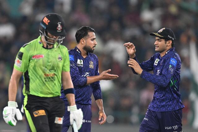 Quetta Gladiators' Faheem Ashraf (C) celebrates with teammate Hasan Nawaz (R) after taking the wicket of Lahore Qalandars' Mohammad Naeem (L) during the Pakistan Super League (PSL) Twenty20 final cricket match between Lahore Qalandars and Quetta Gladiators at the Qaddafi Cricket Stadium in Lahore on May 25, 2025. (Photo by Aamir QURESHI / AFP)