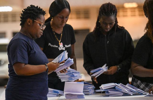Election staffers check ballot papers during the vote count at a polling station during parliamentary elections in Paramaribo on May 25, 2025. S. Suriname began counting votes in parliamentary elections that will decide who will be responsible for distributing the South American country's new-found oil wealth. (Photo by Juan BARRETO / AFP)