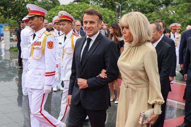 France's President Emmanuel Macron and his wife Brigitte Macron take part in a wreath-laying ceremony at the monument of national heroes and martyrs in Hanoi on May 26, 2025. France's Emmanuel Macron will hold talks on May 26 in Vietnam at the start of his Southeast Asia tour, an opportunity to test his "Indo-Pacific strategy" in a region caught in the middle of the confrontation between the United States and China. (Photo by Ludovic MARIN / AFP)