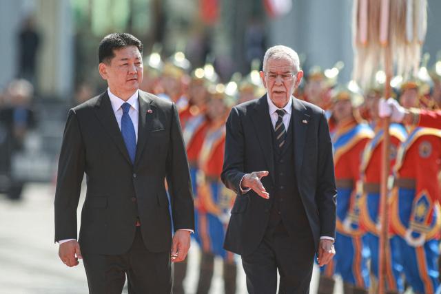 Mongolia's President Ukhnaagiin Khurelsukh (L) and Austria's President Alexander Van der Bellen review the honour guard during a welcome ceremony at Sukhbaatar Square in Ulaanbaatar on May 26, 2025. (Photo by Byambasuren BYAMBA-OCHIR / AFP)