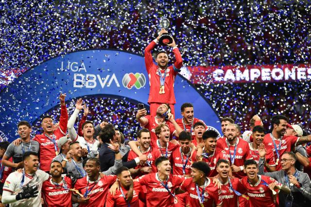Toluca's forward #09 Alexis Vega lifts the trophy with teammates during a ceremony for the Mexican Champions following the Liga MX Clausura football tournament second leg final between Toluca and America at the Nemesio Diez stadium in Toluca de Lerdo, state of Mexico, Mexico on May 25, 2025. (Photo by Rodrigo Oropeza / AFP)