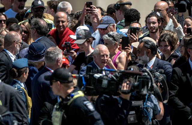 Britain's King Charles III (C) arrives to lay a wreath at The Tomb of the Unknown Soldier at the National War Memorial in Ottawa, Canada on May 27, 2025. King Charles III was given an enthusiastic welcome on May 26 by Canadians who turned out in droves to see their monarch on his historic visit to open parliament, as part of the pushback against US President Donald Trump's annexation threats. The 76-year-old king, who is Canada's head of state as part of the Commonwealth, was greeted at the airport by Prime Minister Mark Carney, who has invited him to give an address opening Canada's new legislature on May 27. (Photo by ANDREJ IVANOV / AFP)