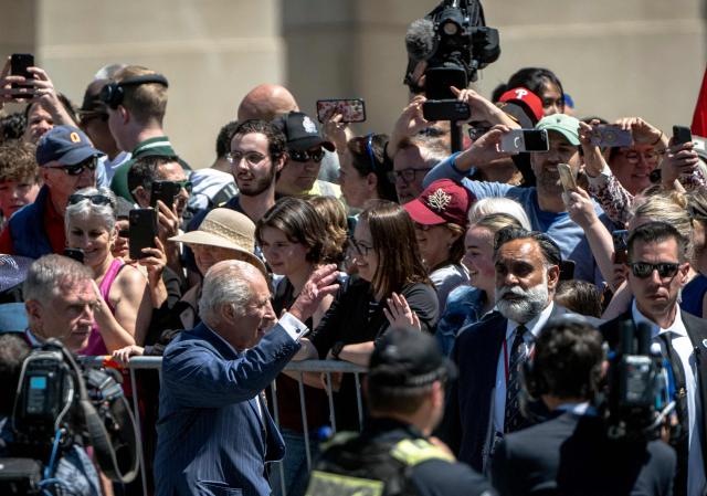 Britain's King Charles III (C L)) arrives to lay a wreath at The Tomb of the Unknown Soldier at the National War Memorial in Ottawa, Canada on May 27, 2025. King Charles III was given an enthusiastic welcome on May 26 by Canadians who turned out in droves to see their monarch on his historic visit to open parliament, as part of the pushback against US President Donald Trump's annexation threats. The 76-year-old king, who is Canada's head of state as part of the Commonwealth, was greeted at the airport by Prime Minister Mark Carney, who has invited him to give an address opening Canada's new legislature on May 27. (Photo by ANDREJ IVANOV / AFP)