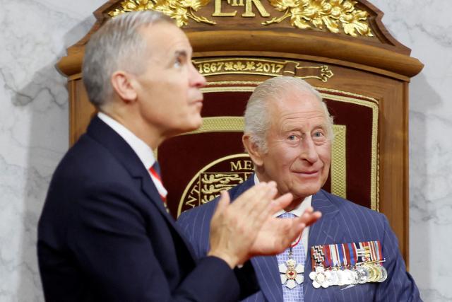 Canada's  Prime Minister Mark Carney claps after Britain's King Charles III delivered the Speech from the Throne during the opening the first session of the 45th Parliament of Canada at the Senate of Canada in Ottawa on May 27, 2025. Britain's King Charles III is heading to Canada for a brief but "impactful" visit, at a time when President Donald Trump is floating the idea of making his northern neighbour the 51st US state. The 76-year-old monarch, who is also Canada's head of state as part of the Commonwealth, has never publicly commented on the ambitions of the US president, a noted admirer of the royal family. (Photo by Blair Gable / POOL / AFP)