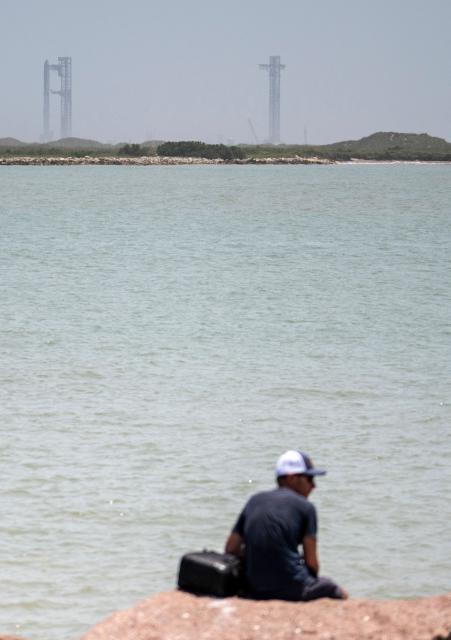 The SpaceX Starship rocket stands on the launchpad ahead of its scheduled launch from the SpaceX Starbase in Boca Chica as seen from South Padre Island, Texas on May 27, 2025. SpaceX said on My 23 it will make another launch attempt next week of the massive Starship rocket -- key to CEO Elon Musk's long-term vision of colonizing Mars -- after two consecutive in-flight explosions earlier this year. "The ninth flight test of Starship is preparing to launch as soon as Tuesday, May 27," the company said on its website, adding the launch window would open at 6:30 pm (2330 GMT) at its base in Texas. (Photo by Sergio FLORES / AFP)