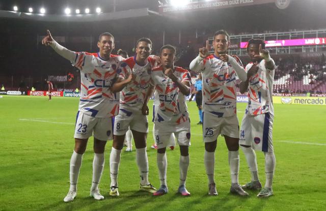 Puerto Cabello's forward #25 Junior Paredes (2-R) celebrates with his teammates Puerto Cabello's Colombian midfielder #23 Oscar Hernandez (L), Puerto Cabello's midfielder #08 Dimas Meza (2-R), Puerto Cabello's Portuguese forward #09 Miguel Tavares (C), and Puerto Cabello's Ghanaian midfielder #14 Abdul Awudu, after scoring his team's first goal during the Copa Sudamericana group stage football match between Argentina's Lanus and Venezuela's Academia Puerto Cabello at the Ciudad de Lanus stadium, in Lanus, Buenos Aires province, Argentina, on May 27, 2025. (Photo by MARCOS BRINDICCI / AFP)