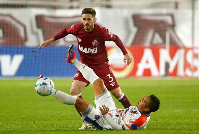 Puerto Cabello's midfielder #06 Junior Cedeno and Lanus' defender #03 Nicolas Morgantini fight for the ball during the Copa Sudamericana group stage football match between Argentina's Lanus and Venezuela's Academia Puerto Cabello at the Ciudad de Lanus stadium, in Lanus, Buenos Aires province, Argentina, on May 27, 2025. (Photo by MARCOS BRINDICCI / AFP)