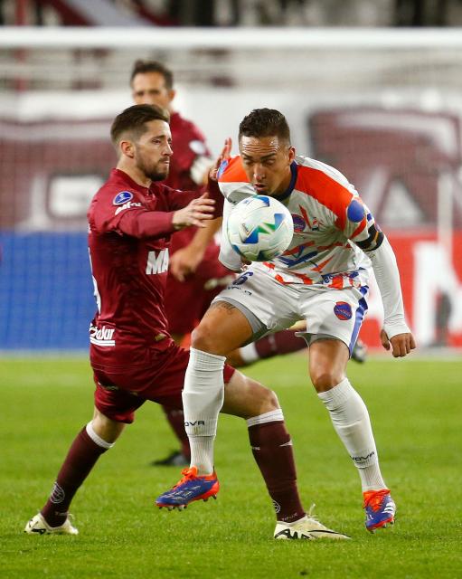 Puerto Cabello's midfielder #06 Junior Cedeno (R) and Lanus' defender #03 Nicolas Morgantini fight for the ball during the Copa Sudamericana group stage football match between Argentina's Lanus and Venezuela's Academia Puerto Cabello at the Ciudad de Lanus stadium, in Lanus, Buenos Aires province, Argentina, on May 27, 2025. (Photo by MARCOS BRINDICCI / AFP)