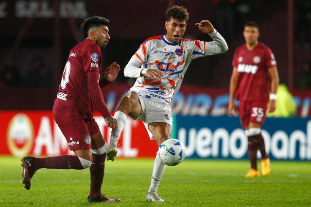 Lanus' midfielder #10 Marcelino Moreno (R) and Puerto Cabello's midfielder #28 Diego Osorio fight for the ball during the Copa Sudamericana group stage football match between Argentina's Lanus and Venezuela's Academia Puerto Cabello at the Ciudad de Lanus stadium, in Lanus, Buenos Aires province, Argentina, on May 27, 2025. (Photo by MARCOS BRINDICCI / AFP)