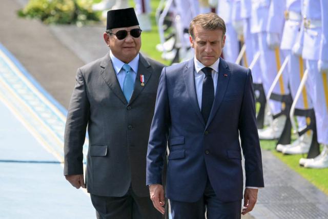Indonesia's President Prabowo Subianto (L) and France's President Emmanuel Macron (R) walk together during a welcoming ceremony at Merdeka Palace in Jakarta on May 28, 2025. (Photo by BAY ISMOYO / AFP)