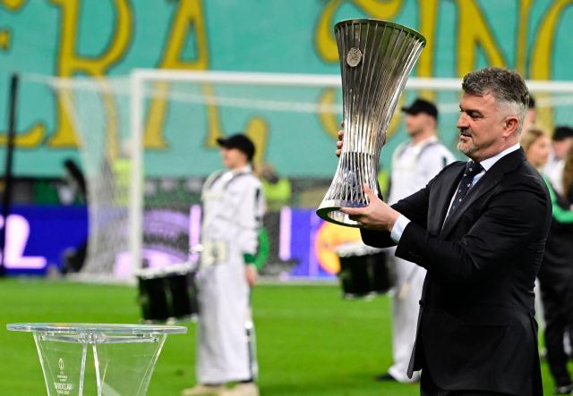 Former Polish football player Michal Zewlakow carries the trophy ahead the UEFA Conference League final football match between Real Betis and Chelsea FC in Wroclaw on May 28, 2025. (Photo by John MACDOUGALL / AFP)