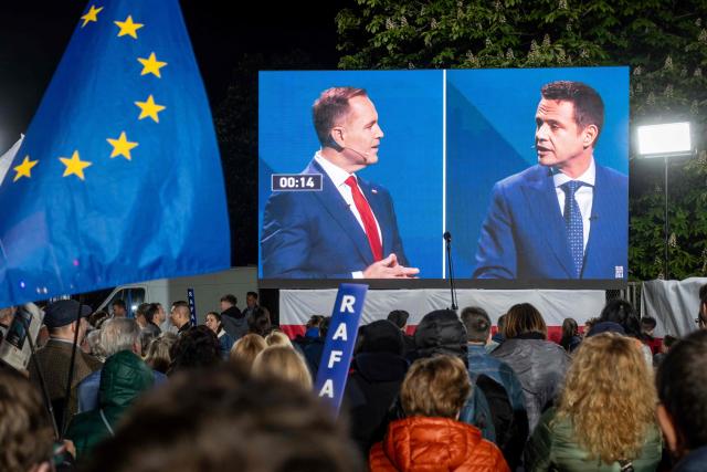 (FILES) Supporters of Warsaw's mayor and member of Polands ruling Civic Coalition party Rafal Trzaskowski (R), observe their candidate during the discussion with his main opponent Karol Nawrocki (L), candidate for the 2025 Polish presidential election supported by Poland's right-wing Law and Justice (PiS) party during the transmission of the presidential debate on giant screen in front of the Polish National Television headquarters in Warsaw on May 12, 2025. A large water park has pride of place in the heart of Polish village Kleszczow -- an apparent sign of the prosperity of the area known as "the Polish Kuwait". But residents worry these riches will come to an end. That was a chief concern when they overwhelmingly voted for the far-right in round one of the presidential election this month. The far-right is now playing kingmaker ahead of the June 1 runoff, which will pit pro-EU Warsaw mayor Rafal Trzaskowski against nationalist historian Karol Nawrocki. (Photo by Wojtek RADWANSKI / AFP)