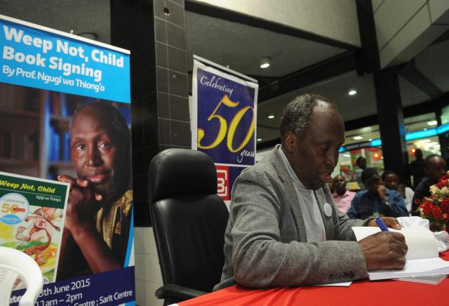 (FILES) Internationally celebrated author, playwright and critic, Kenyan Ngugi wa Thiong'o autographs a copy of one of his books for a fan, on June 13, 2015 during a book signing to celebrate the golden jubilee of his first book 'Weep Not Child'  in the Kenyan capital, Nairobi. Kenyan author Ngugi wa Thiong'o, considered one of east Africa's greatest literary figures, died on May 29, 2025, his daughter announced on Facebook. He was 87. (Photo by TONY KARUMBA / AFP)