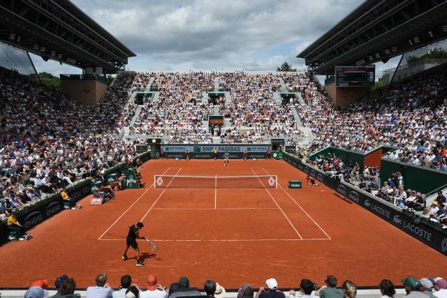 Spain's Jaume Munar (front) plays a forehand return to France's Arthur Fils during their men's singles match on day 5 of the French Open tennis tournament on Court Suzanne-Lenglen at the Roland-Garros Complex in Paris on May 29, 2025. (Photo by Dimitar DILKOFF / AFP)