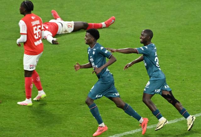 Metz's Gambian midfielder #36 Ablie Jallow (R) and Metz's Senegalese midfielder #12 Alpha Toure (C) celebrate after scoring their team's third goal during the French L1-L2 playoff second leg football match between Stade de Reims and FC Metz at Stade Auguste-Delaune in Reims, northern France on May 29, 2025. (Photo by FRANCOIS NASCIMBENI / AFP)