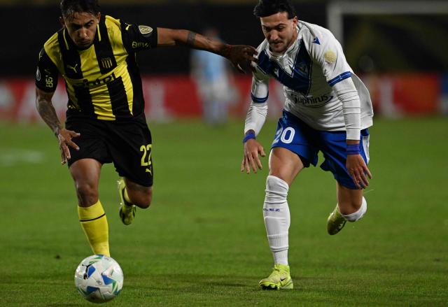 Penarol's defender #22 Damian Suarez and Velez Sarsfield's forward #20 Francisco Pizzini fight for the ball during the Copa Libertadores group stage football match between Uruguay's Penarol and Argentina's Velez Sarsfield, at the Campeon del Siglo stadium in Montevideo, on May 29, 2025. (Photo by Eitan ABRAMOVICH / AFP)