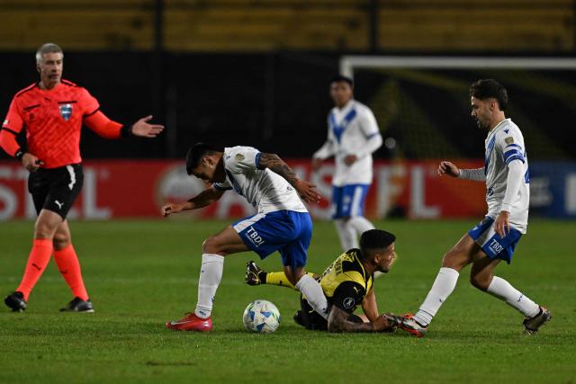 Penarol's forward #07 Javier Cabrera (C) fights for the ball with Velez Sarsfield's Chilean midfielder #05 Claudio Baeza (L) and forward #26 Agustin Bouzat during the Copa Libertadores group stage football match between Uruguay's Penarol and Argentina's Velez Sarsfield, at the Campeon del Siglo stadium in Montevideo, on May 29, 2025. (Photo by Eitan ABRAMOVICH / AFP)