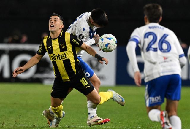 Penarol's midfielder #10 Leonardo Fernandez and Velez Sarsfield's defender #06 Aaron Quiros (back) fight for the ball during the Copa Libertadores group stage football match between Uruguay's Penarol and Argentina's Velez Sarsfield, at the Campeon del Siglo stadium in Montevideo, on May 29, 2025. (Photo by Eitan ABRAMOVICH / AFP)