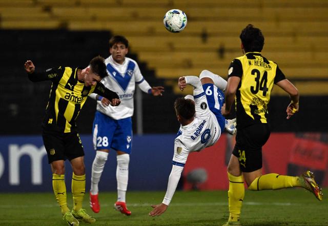 Penarol's midfielder #32 Leandro Umpierrez (L) and Velez Sarsfield's forward #09 Braian Romero fight for the ball past Penarol's defender #34 Nahuel Herrera and Velez Sarsfield's forward #28 Maher Carrizo during the Copa Libertadores group stage football match between Uruguay's Penarol and Argentina's Velez Sarsfield, at the Campeon del Siglo stadium in Montevideo, on May 29, 2025. (Photo by Eitan ABRAMOVICH / AFP)