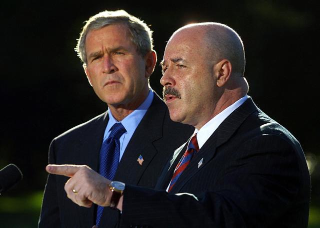 (FILES) This  October 3, 2003, file photo shows former New York City Police Commissioner Bernard Kerik (R), with US President George W. Bush (L), addressing the media on the South Lawn of the White House in Washington, DC. Former NYPD Commissioner Bernard Kerik died on May 29, 2025 at the age of 69. In a post on social media, FBI Director Kash Patel said Kerik passed away on Thursday after a private battle with an illness. Kerik was former New York City Mayor Rudy Giuliani's commissioner from 2000 to 2001, and served during the 9/11 terrorist attacks. (Photo by Manny CENETA / AFP)