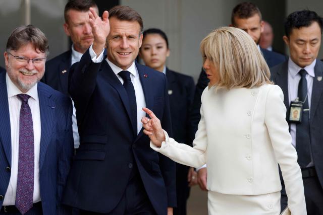 France's President Emmanuel Macron (centre L) waves next to his wife Brigitte Macron (2nd R) as he meets with members of the French community at the International French School (IFS) in Singapore on May 30, 2025. (Photo by Ludovic MARIN / AFP)