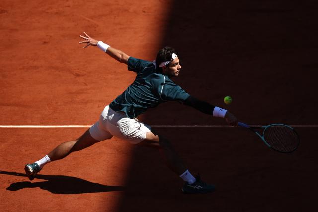 Italy's Lorenzo Musetti plays a backhand return to Argentina's Mariano Navone during their men's singles match on day 6 of the French Open tennis tournament on Court Suzanne-Lenglen at the Roland-Garros Complex in Paris on May 30, 2025. (Photo by Anne-Christine POUJOULAT / AFP)