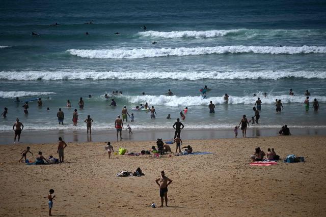 People enjoy the beach on a warm afternoon along the Atlantic Ocean in Lacanau, south-western France on May 30, 2025. (Photo by Christophe ARCHAMBAULT / AFP)