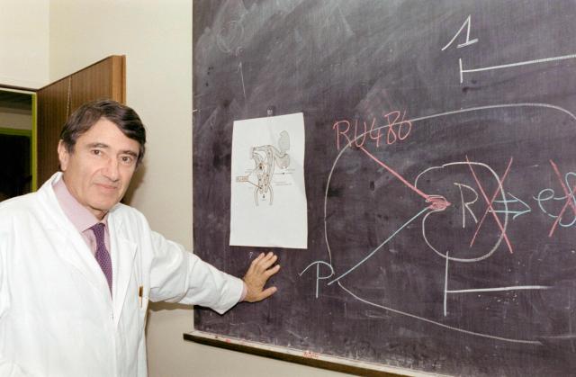 (FILES) French biochemist, endocrinologist and researcher Etienne-Emile Baulieu poses on October 31, 1988 with diagram describing function of his invention, the abortion-inducing RU-486 pill, at the Bicêtre Hospital in Le Kremlin-Bicêtre. Etienne-Emile Baulieu is best known for his research in the field of steroid hormones and their role in reproduction and aging. (Photo by Pierre GUILLAUD / AFP)
