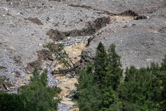 This photograph shows the river Lonza, choked with debris, in the middle of the massive landslide that destroyed the village of Blatten after the huge Birch Glacier collapsed and a massive landslide that threw tons of rock, ice and scree down the mountainside and into the valley below in Wiler on May 31, 2025. Swiss authorities said on May 30, 2025 that they were no longer considering evacuating most residents in the vicinity of a collapsed glacier that destroyed a village, but that they remained vigilant. The Birch glacier in Switzerland's southern Valais region collapsed on May 28, 2025 sending a mass of rock, ice and scree hurtling into the village of Blatten in the valley below. (Photo by Fabrice COFFRINI / AFP)