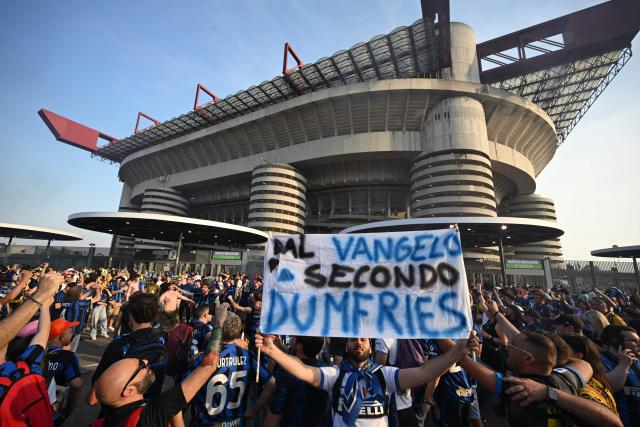 Inter fans, one holding a banner reading "The Gospel According to Dumfries" cheer outside the San Siro stadium prior to the screening of the UEFA Champions League final football match between Paris Saint-Germain (PSG) and Inter Milan held in Munich, in Milan on May 31, 2025. (Photo by PIERO CRUCIATTI / AFP)