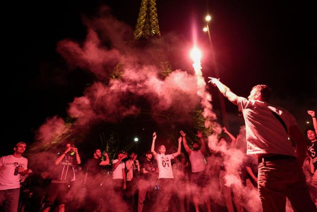 Paris Saint-Germain's supporters light smoke flares in front of The Eiffel Tower in Paris on May 31, 2025, during celebrations following their 5-0 victory in the UEFA Champions League final football match between Paris Saint-Germain (PSG) and Inter Milan held in Munich. (Photo by Thibaud MORITZ / AFP)
