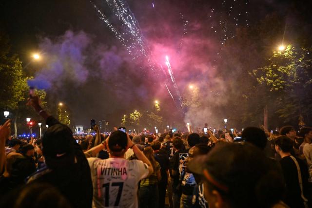 Paris Saint-Germain supporters celebrate with fireworks on the Champs-Elysees avenue in the last minutes of the UEFA Champions League final football match between Paris Saint-Germain (PSG) and Inter Milan held in Munich, in Paris on May 31, 2025. (Photo by LOU BENOIST / AFP)