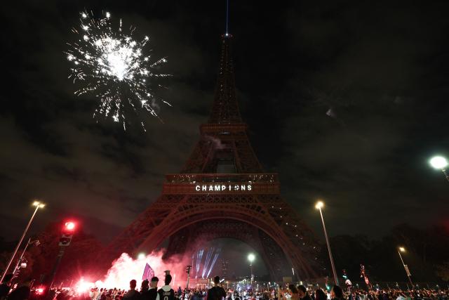 Fireworks explode next to The Eiffel Tower reading "Champions" in Paris on May 31, 2025, during celebrations following their 5-0 victory in the UEFA Champions League final football match between Paris Saint-Germain (PSG) and Inter Milan held in Munich. (Photo by Thibaud MORITZ / AFP)
