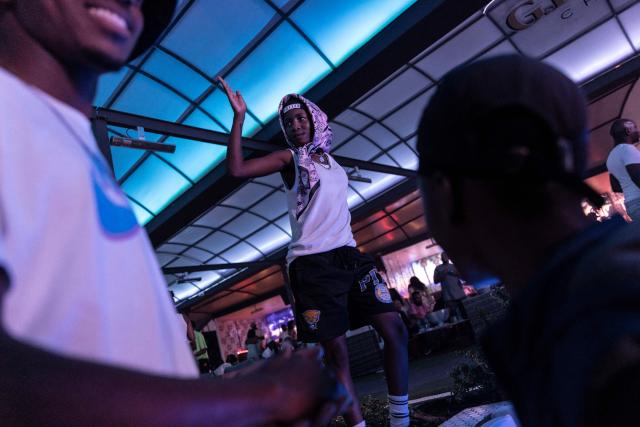 (FILES) People dance in the VIP area of a nightclub during an amapiano party in Gauteng, Johannesburg, on February 26, 2022. On a viral video of Manchester United’s Paul Pogba, fresh from a haircut, rhythmically jutting his chin to the sky to the catchy sound, or perhaps during a TikTok binge while trying to memorise a dancer’s slick footwork, you might have not known it then but that’s Amapiano -- a uniquely South African genre. “The pianos” in Zulu - what you hear blended in with some deep house, a jazzy soulful beat, and a lot of bass -  have catapulted from the country’s townships to the world. (Photo by GUILLEM SARTORIO / AFP)