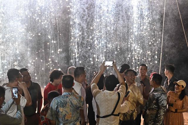 Chinese nationals Song Jihan and Wang Zengyi enjoy fireworks with their loved ones during their wedding reception on the beach near Pattaya in Chonburi province on May 31, 2025. When Wang Zengyi, 41, and Song Jihan, 29, first met at a friend's dinner party in China, it was love at first sight. Nearly three years later, the gay Chinese couple are getting married in Thailand, which became Asia's largest nation to legalise same-sex marriage earlier this year - including for foreign couples. (Photo by Lillian SUWANRUMPHA / AFP) / To go with Thailand-China-rights-LGBTQ, REPORTAGE by Sarah LAI (STF), Sally JENSEN