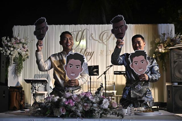 Chinese nationals Song Jihan (R) and Wang Zengyi (L) play games during their wedding reception near Pattaya in Chonburi province on May 31, 2025. When Wang Zengyi, 41, and Song Jihan, 29, first met at a friend's dinner party in China, it was love at first sight. Nearly three years later, the gay Chinese couple are getting married in Thailand, which became Asia's largest nation to legalise same-sex marriage earlier this year - including for foreign couples. (Photo by Lillian SUWANRUMPHA / AFP) / To go with Thailand-China-rights-LGBTQ, REPORTAGE by Sarah LAI (STF), Sally JENSEN